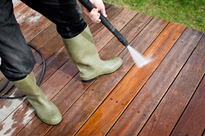 Person Pressure Washing a Wooden Deck Marietta GA