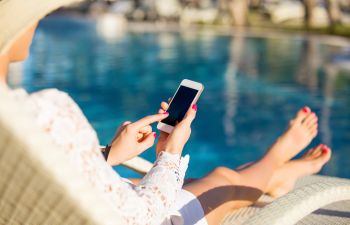 Woman relaxing in a chair on pool deck.